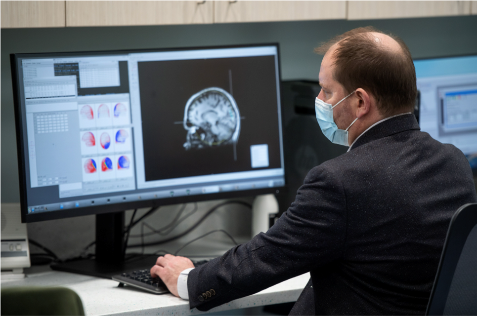Doctor sitting at a computer looking at a brain scan image