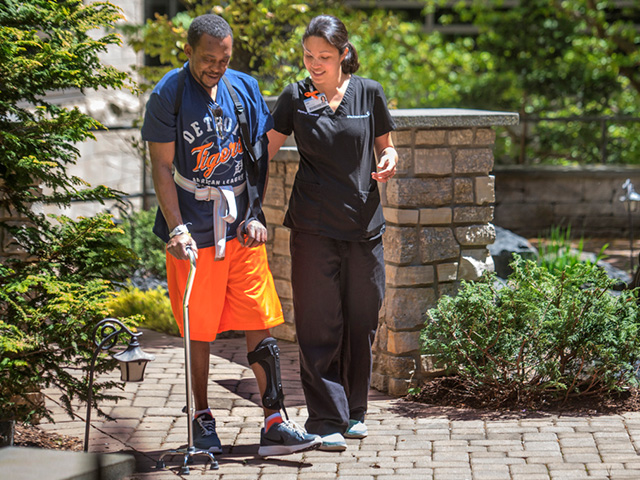Healthcare provider helping man with cane