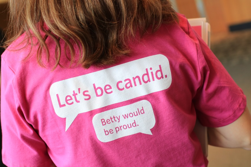 Girl in pink shirt that says Lets Be Candid