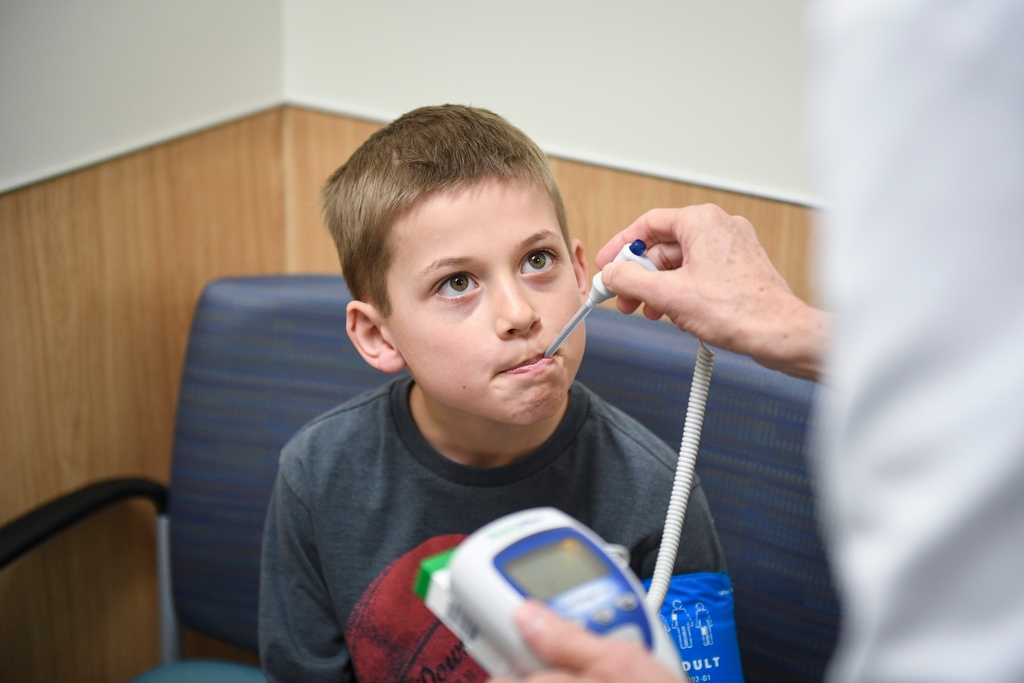 Child getting their temperature taken by a provider.