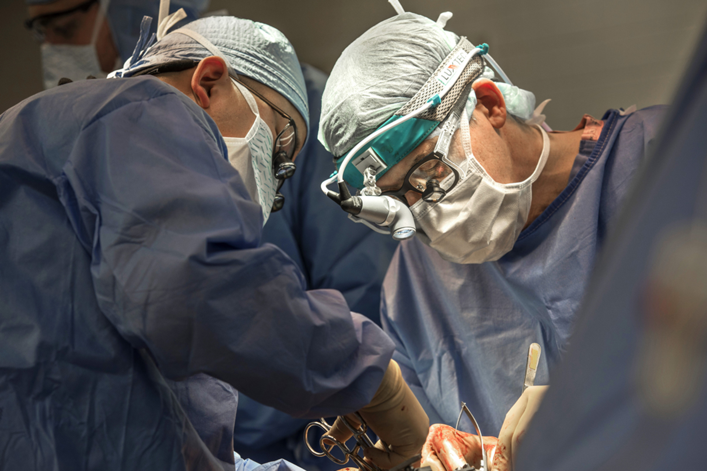 Two healthcare providers performing surgery