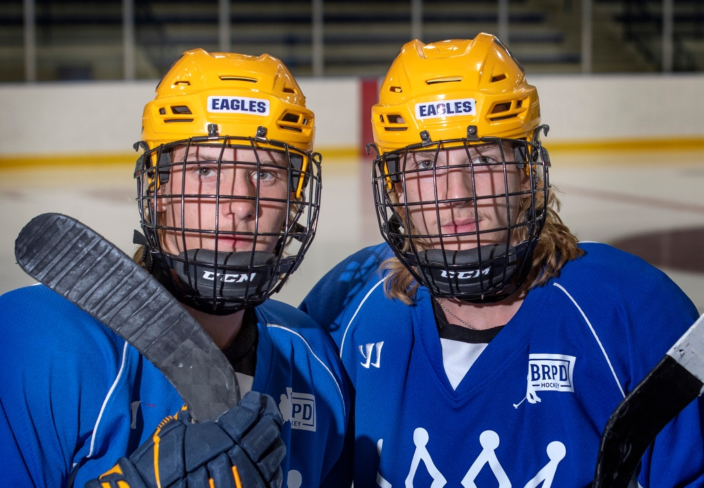 Twin brothers wearing hockey helmets