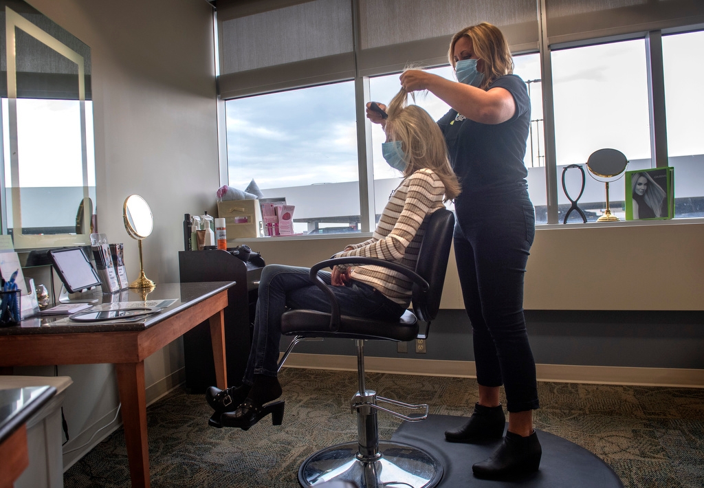 Hair stylist fixing womans hair