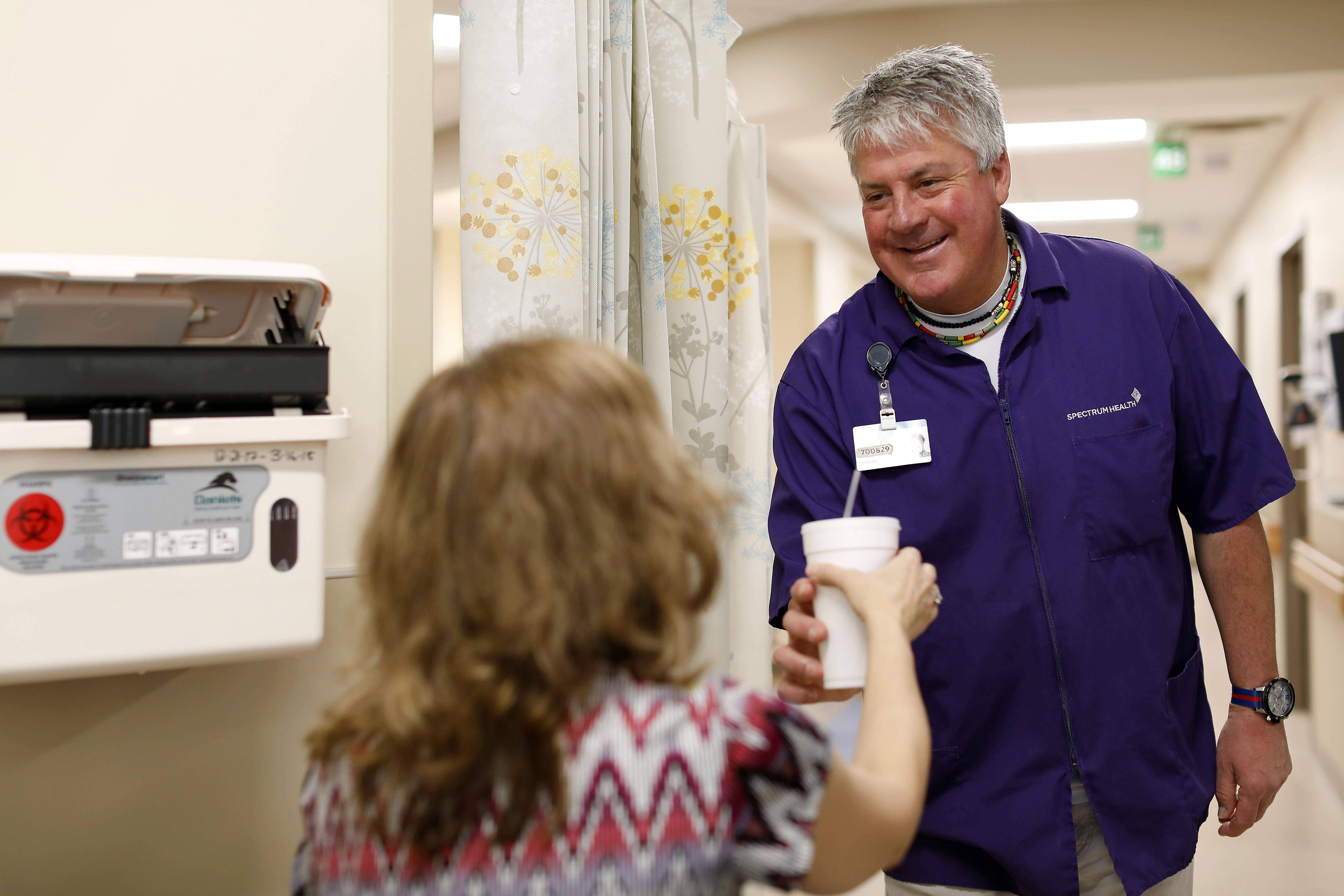 Volunteer handing a patient a cup of water