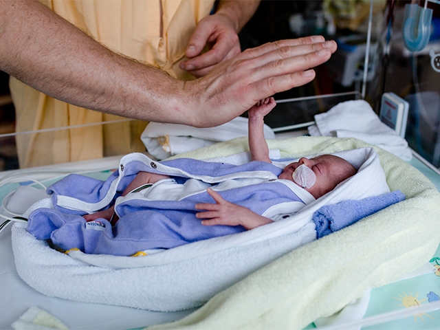 Parents with their baby in the NICU