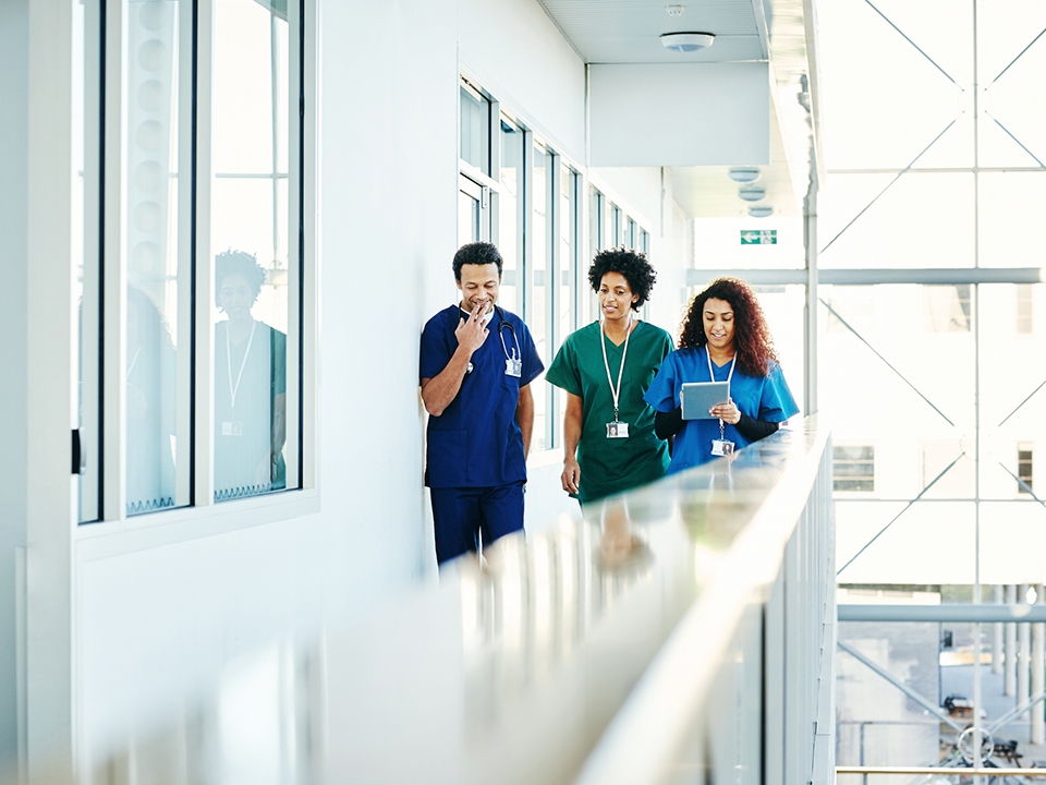 Three healthcare providers walking down a hall.
