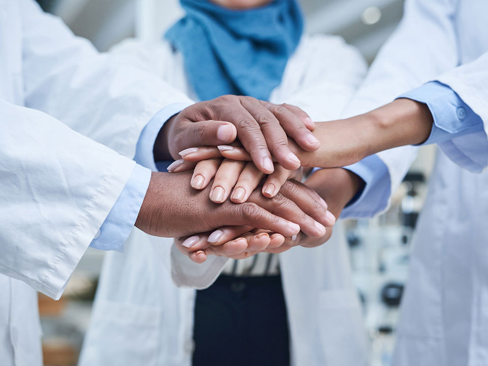 Physicians' hands in a teamwork pile
