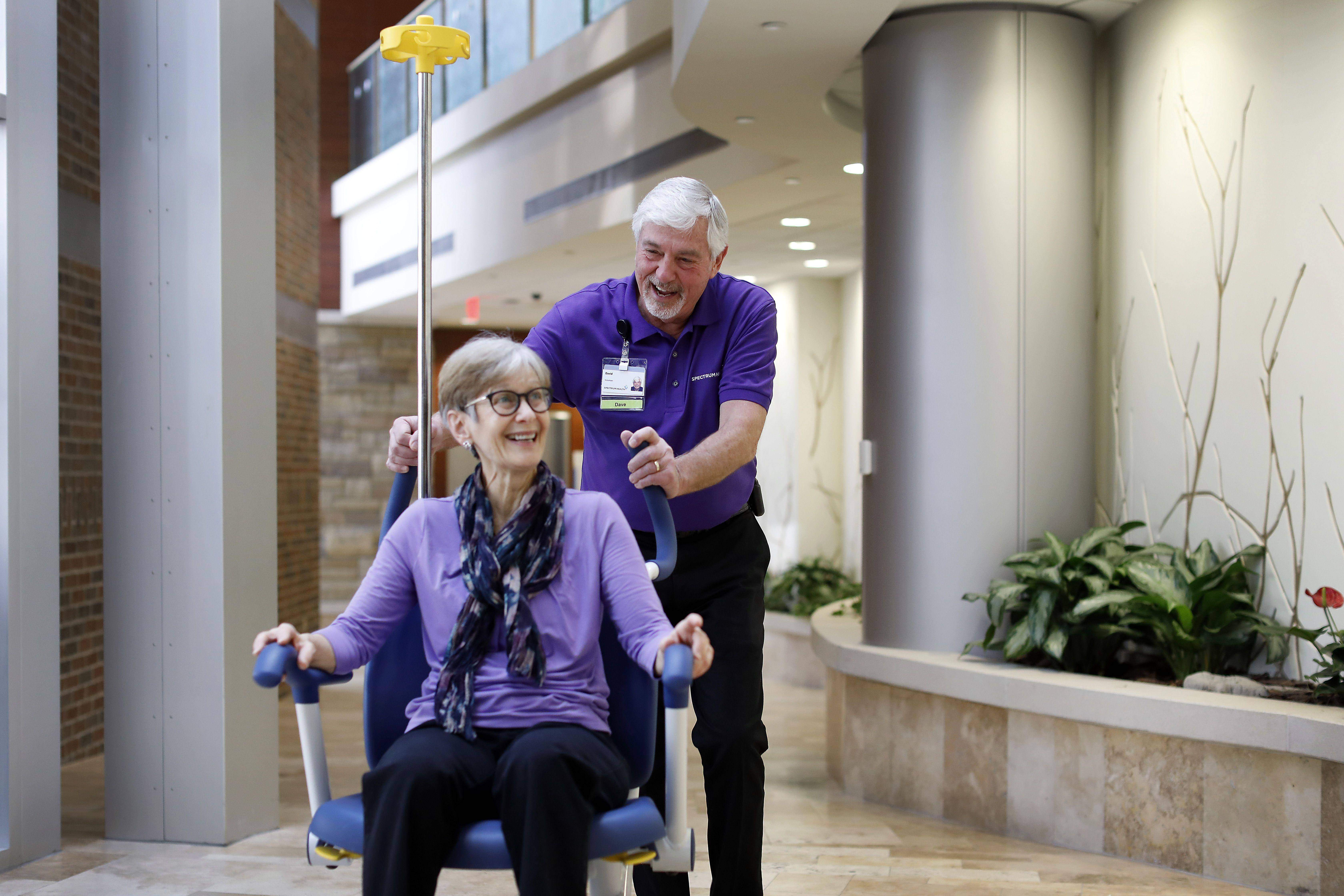 Volunteer pushing an older lady around