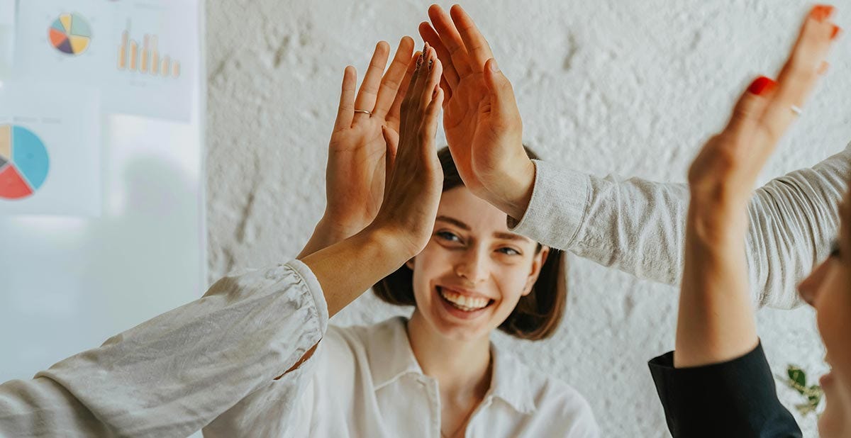 Group of students giving each other a high-five after getting French numbers and their conjugation right