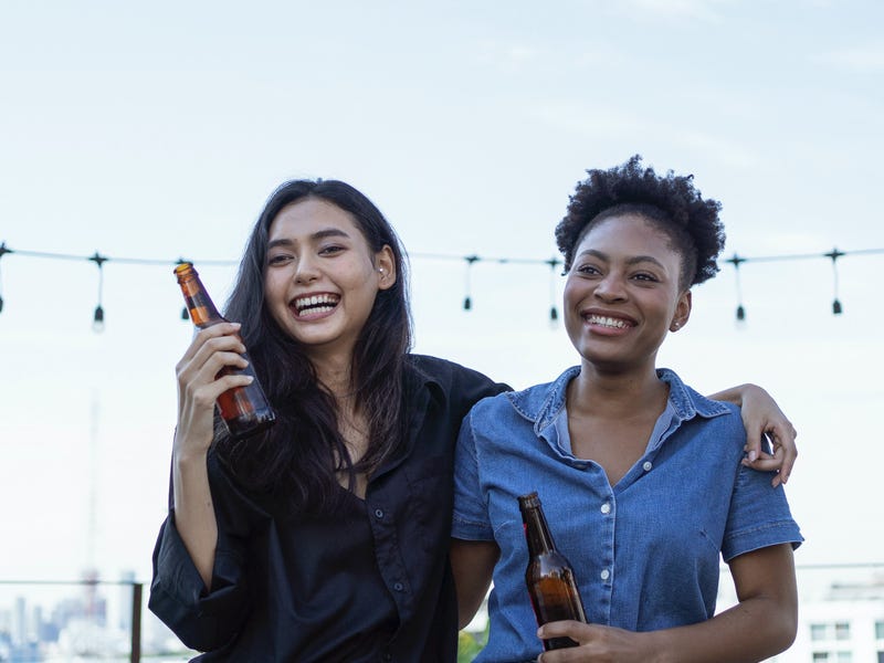 Two friends having a chat on a rooftop party