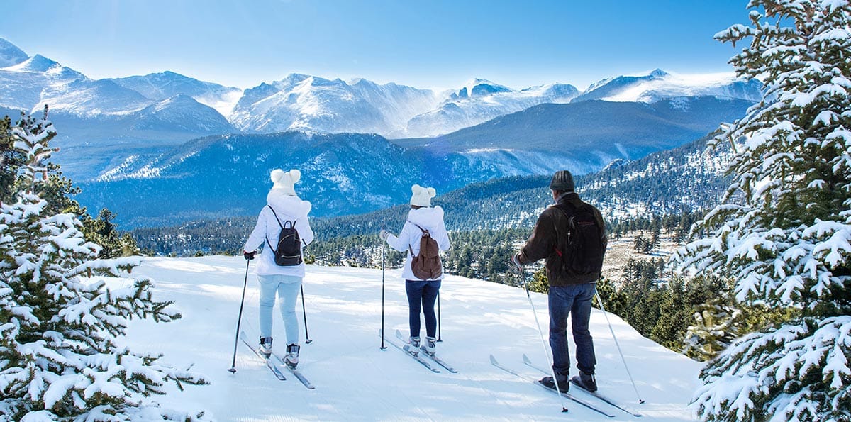 Family trekking in the snow and looking at some mountains in America