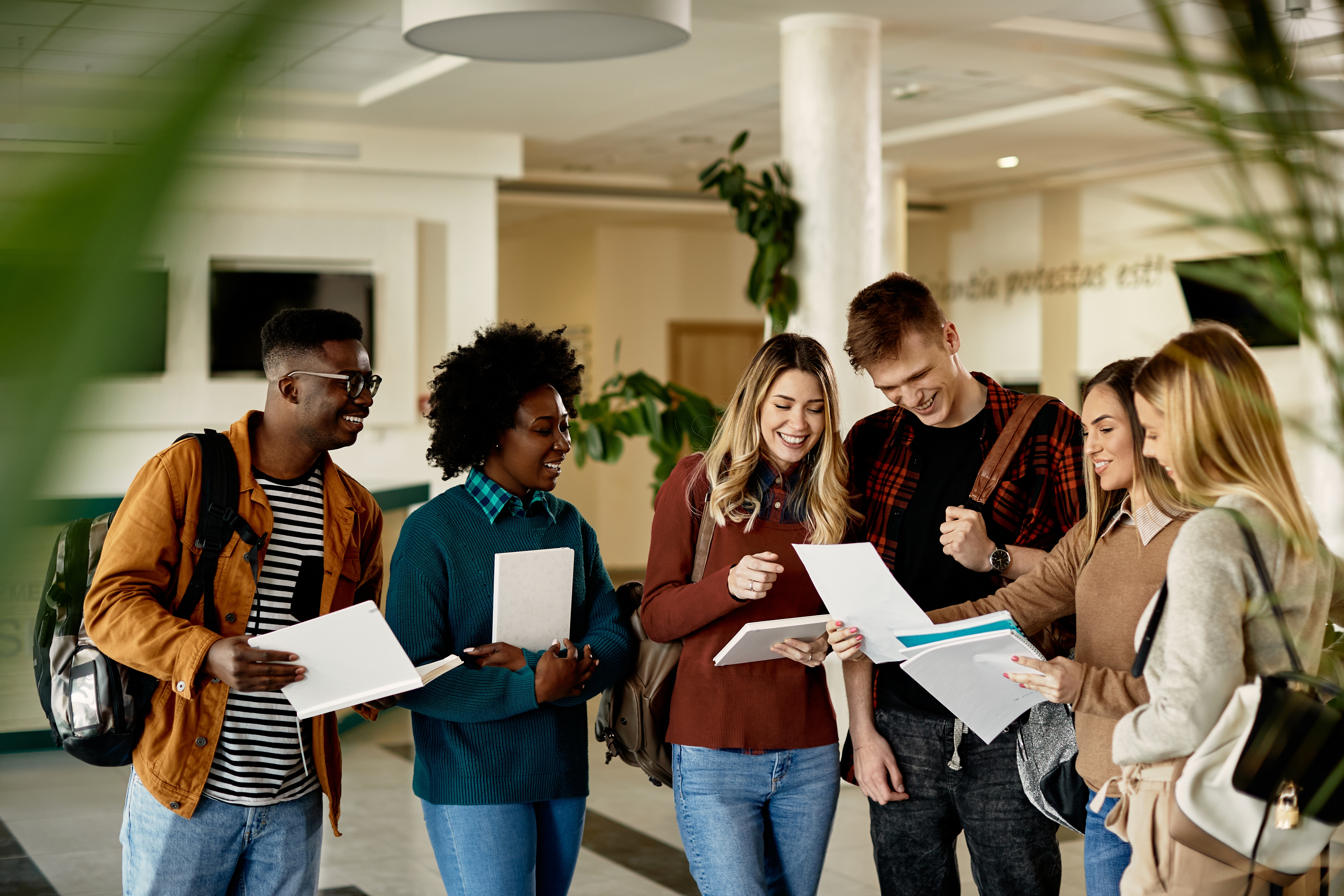 Berlitz students holding their notes and talking to each other excitedly