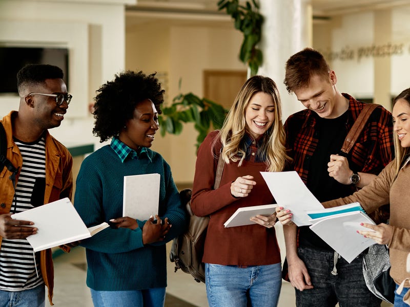 Berlitz students holding their notes and talking to each other excitedly