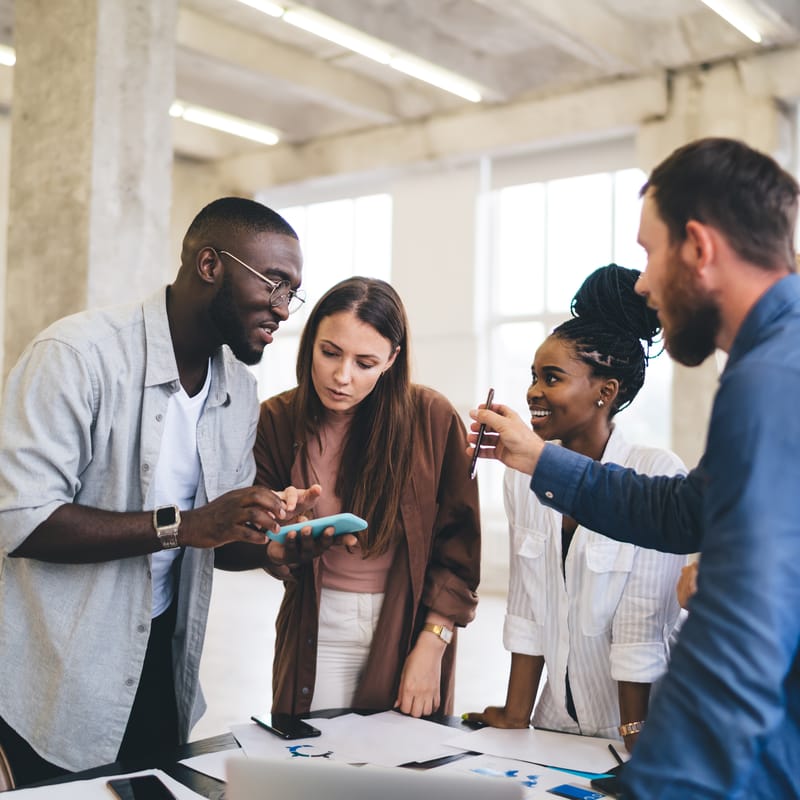 Coworkers around a table talking to each other