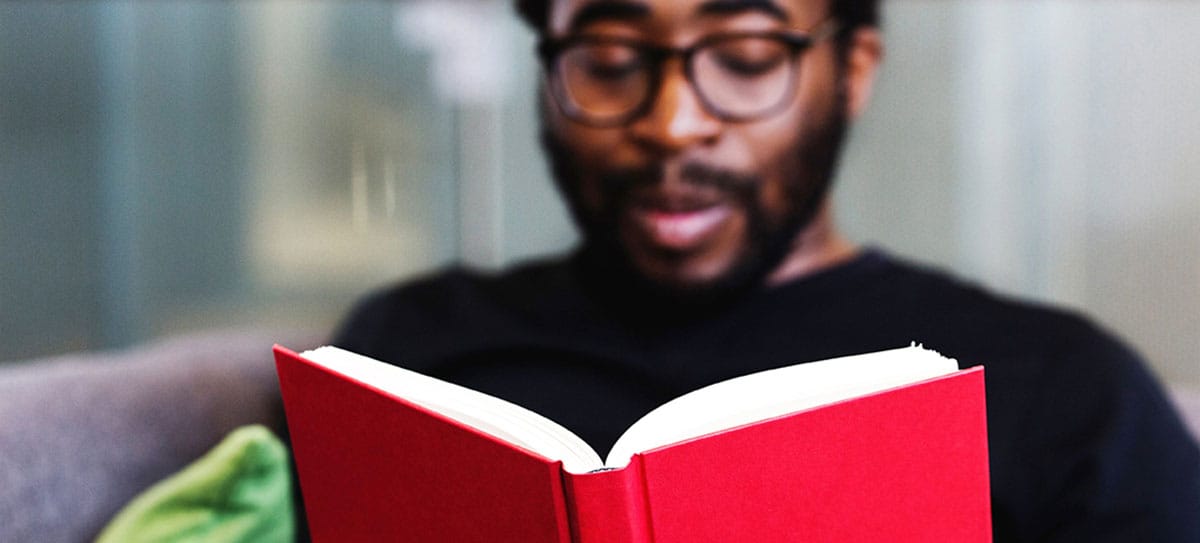 Man reading a book about English vowels