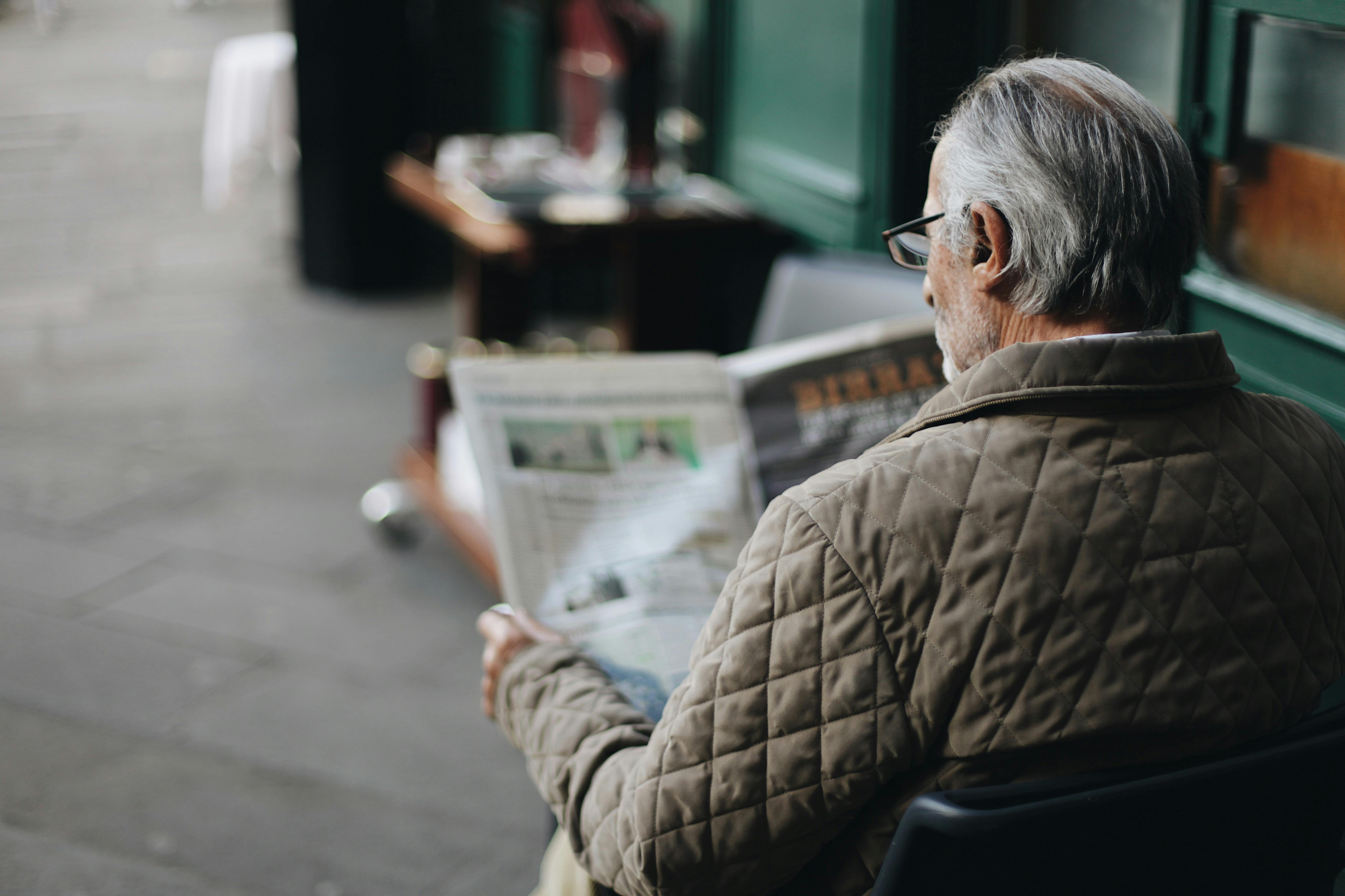 Man reading a newspaper written in future simple tense