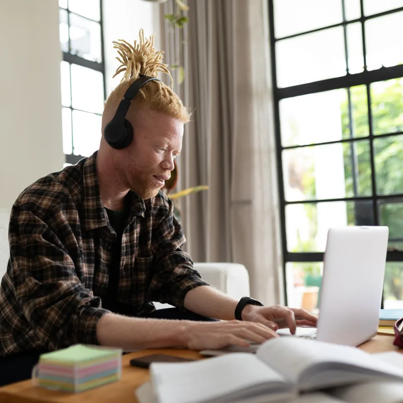Man with headphones learning a langauge with Berlitz's AI tools online