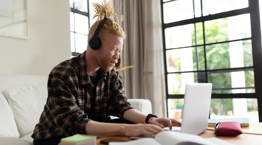 Man with headphones learning a langauge with Berlitz's AI tools online