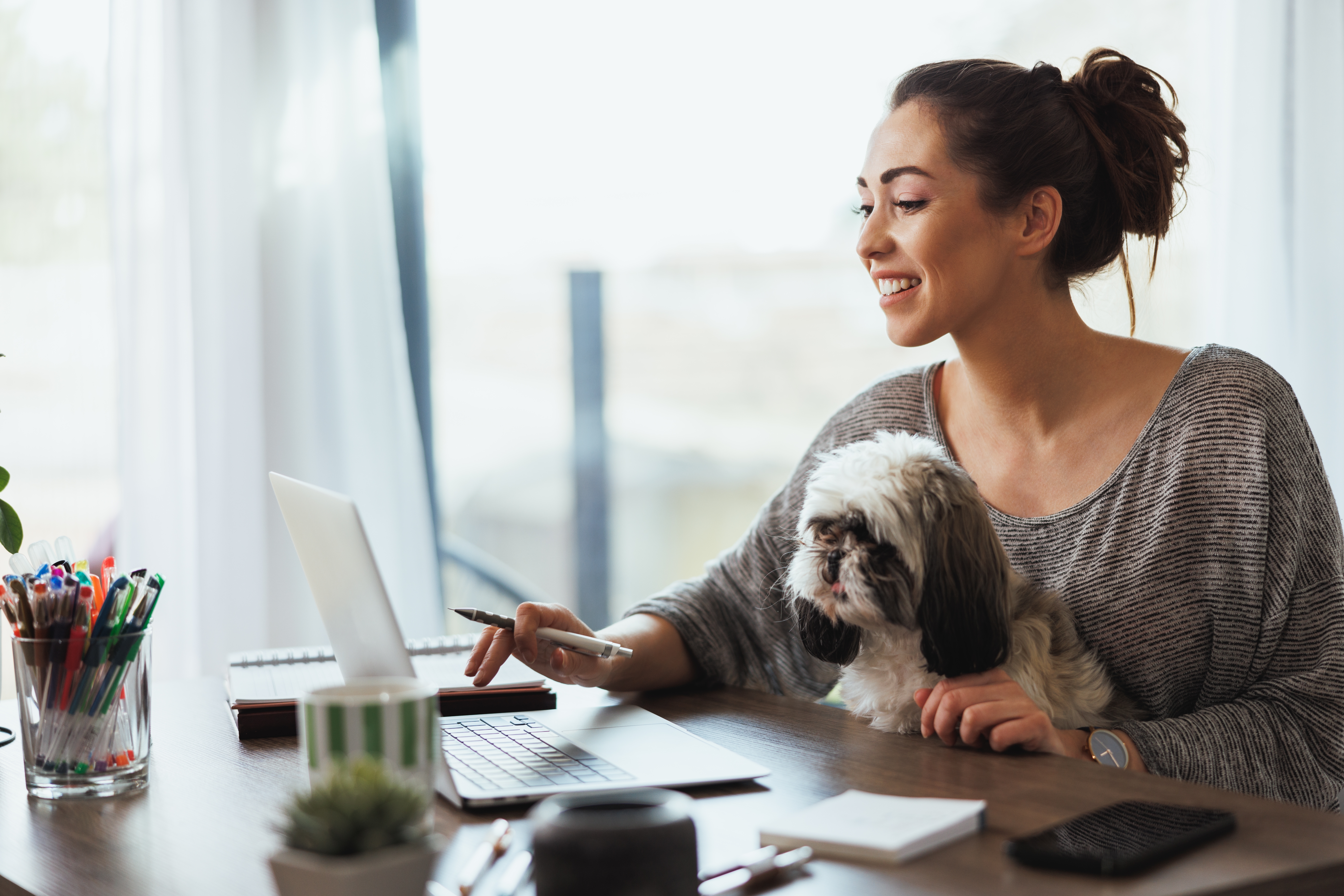 Woman sitting on the couch with her laptop and practicing her speaking skills with Berlitz's AI-assisted learning tool