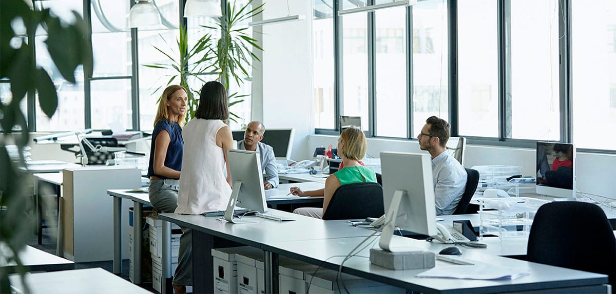Colleagues sittin around a table at their workplace and having a business meeting in Italian