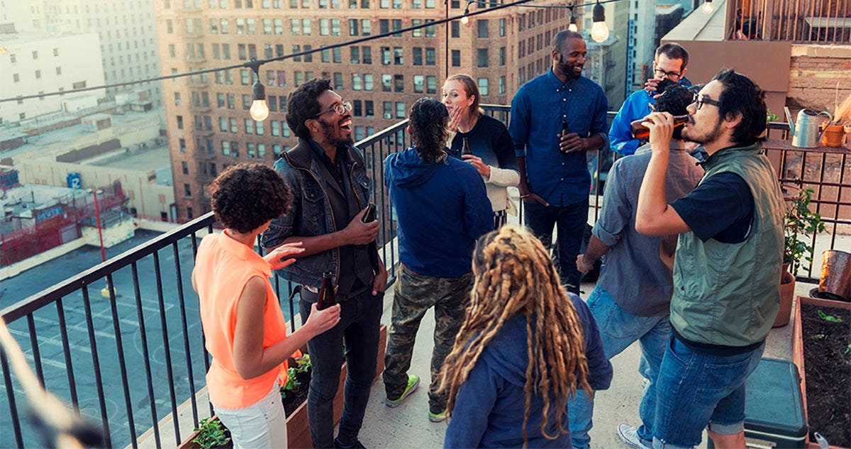 Coworkers attending a rooftop party together after closing a deal successfully