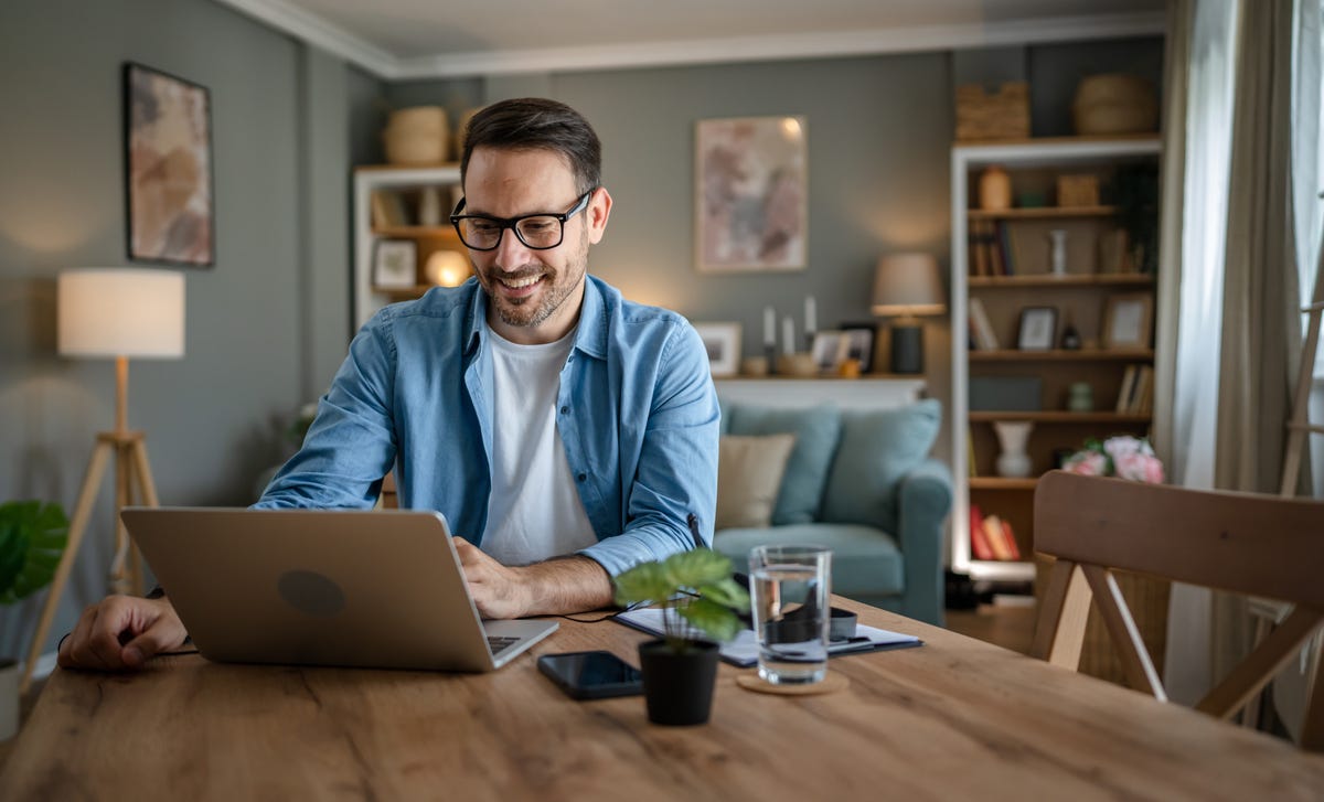 Man reading the answers on the Berlity FAQ page in his living room