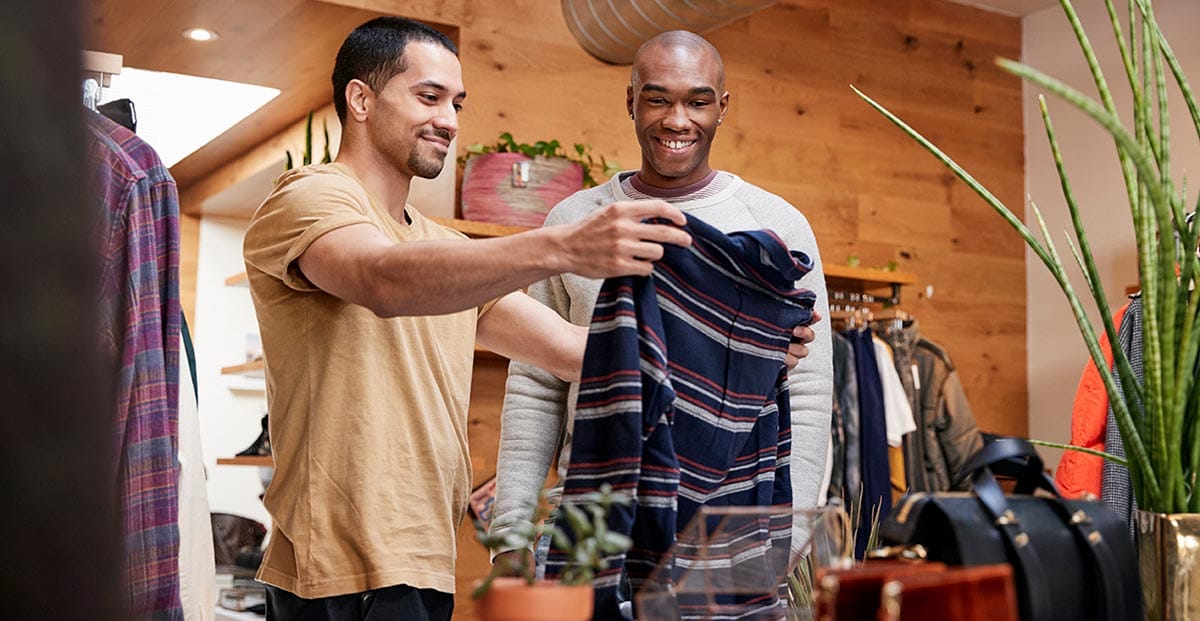 Two friends looking at clothes together in a shop