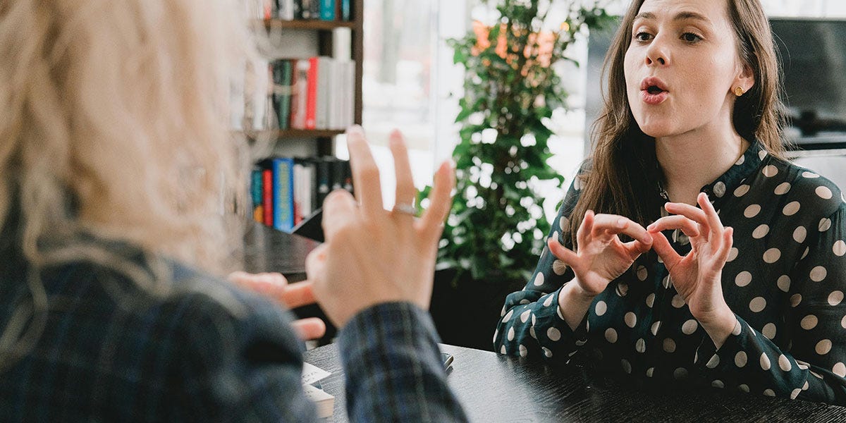 Man and woman talking to each other using the American Sign Language
