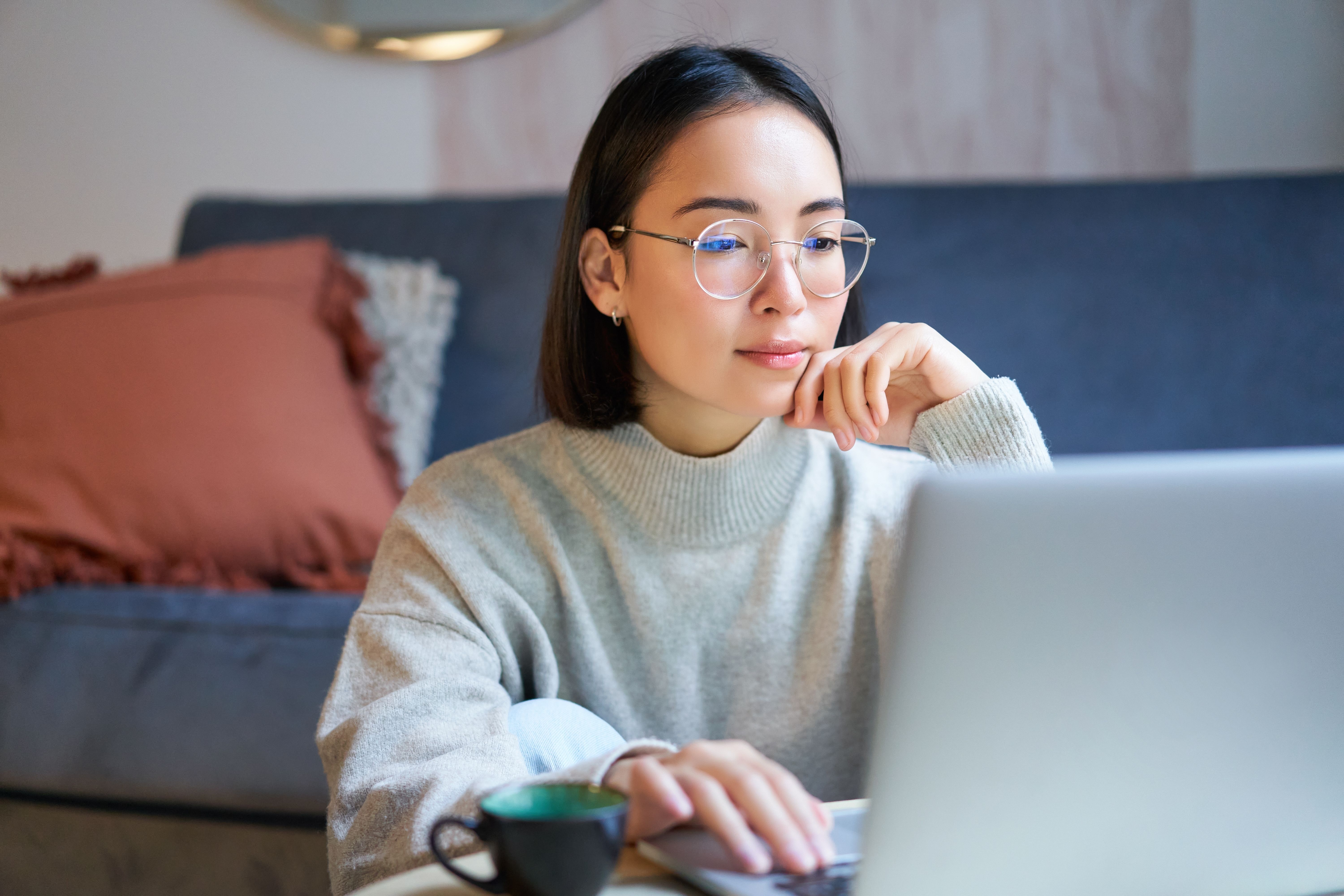 Woman in front of a laptop learning a language online with AI and live instructors