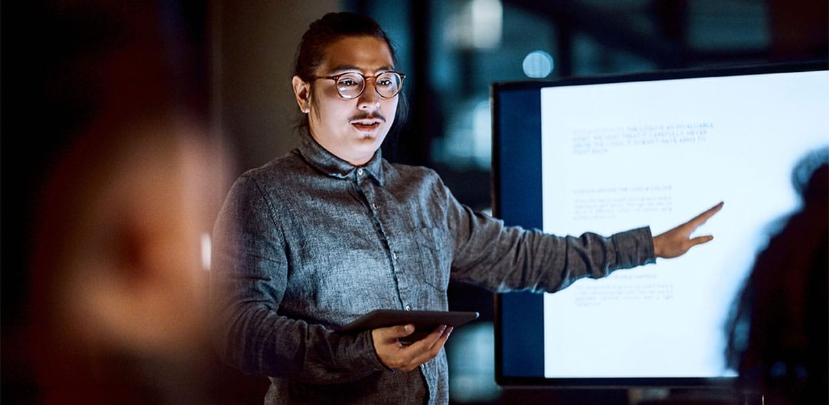 Man presenting in a business meeting in Italian