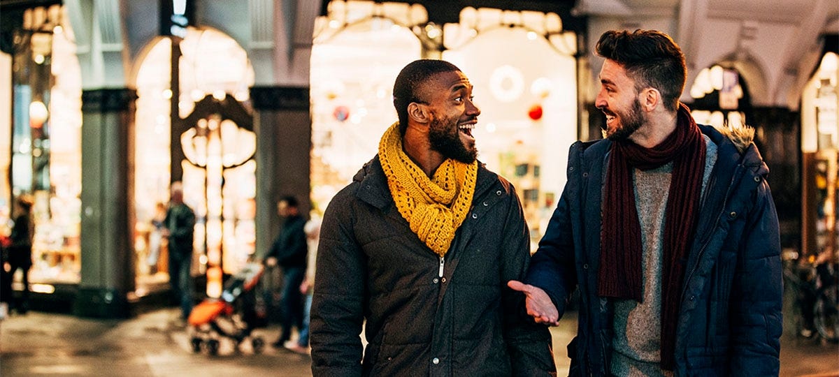 Two friends talking to each other happily on the street