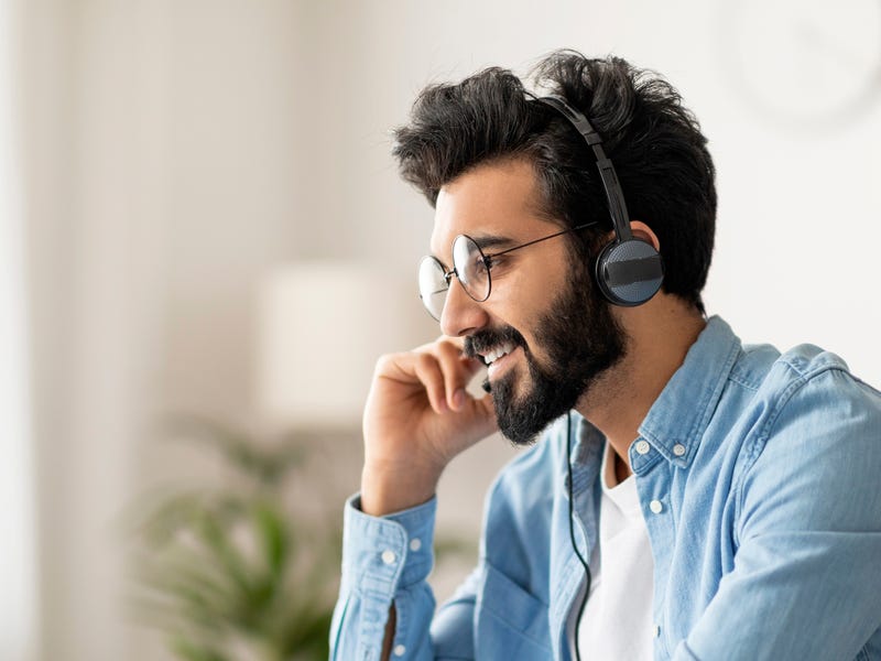 Man with headphones doing AI practices with Berlitz to build confident speaking and communication skills