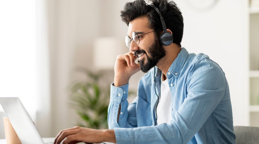 Man with headphones doing AI practices with Berlitz to build confident speaking and communication skills