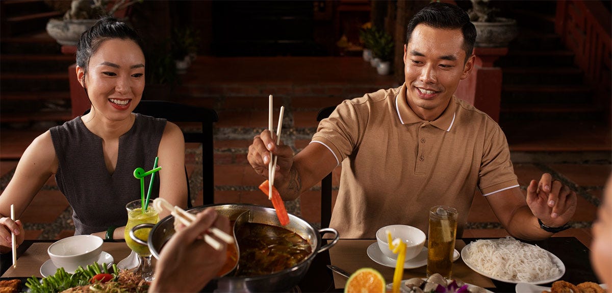 Friend group eating Vietnamese food in a restaurant