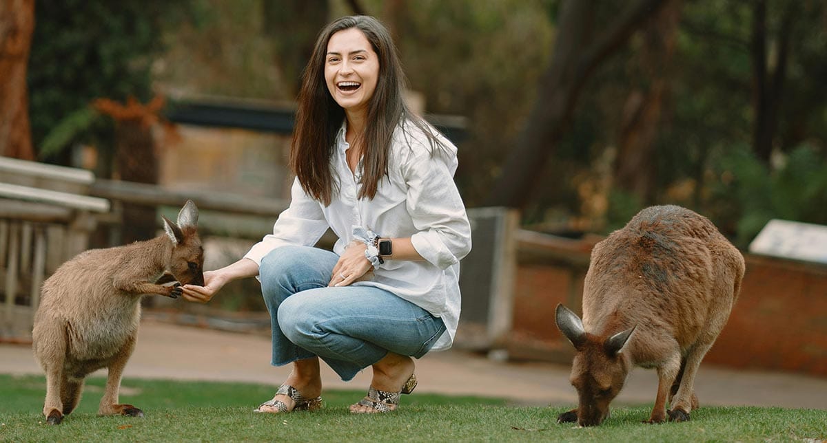 Woman smiling while feeding kangaroos