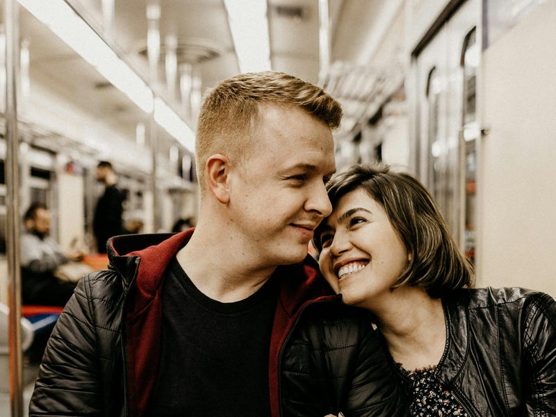 Couple smiling at each other on the tram after their date