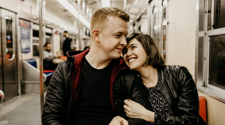 Couple smiling at each other on the tram after their date