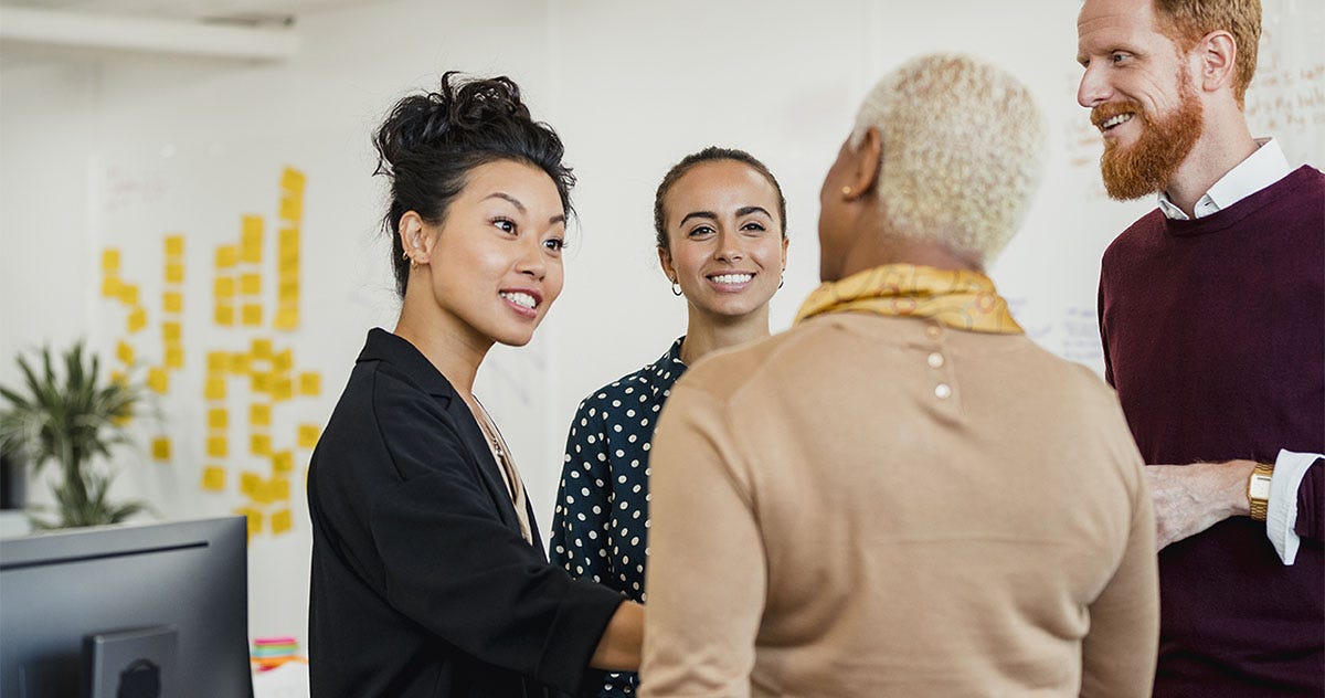 Coworkers at their workplace chatting excidetly