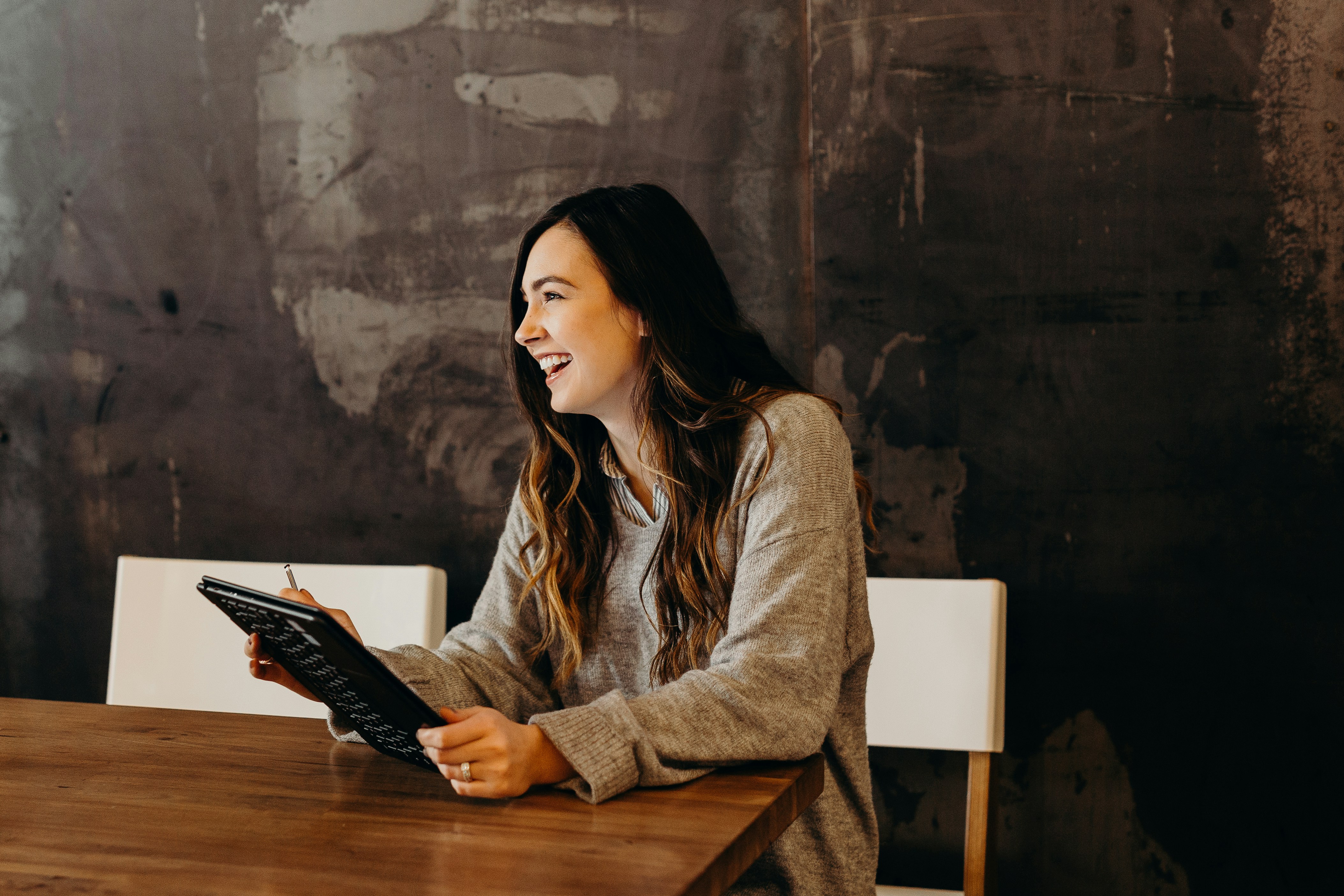 Woman in a restaurant laughing with her friend while using the past continuous tense