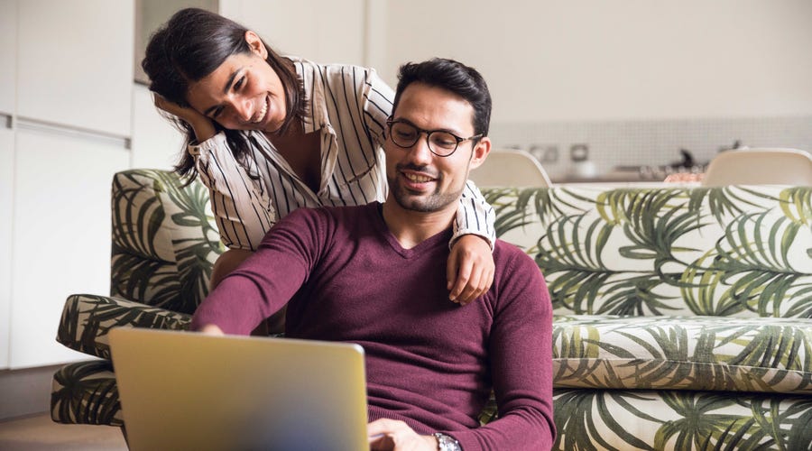 Couple in front of a laptop deciding whether to learn Spanish or Italian