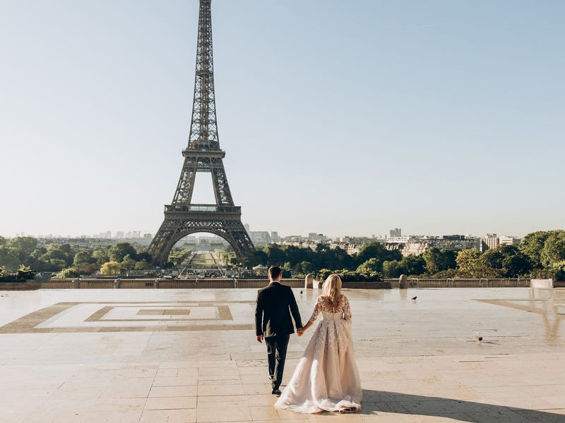 Couple during their wedding walking to towards the Eiffel Tower