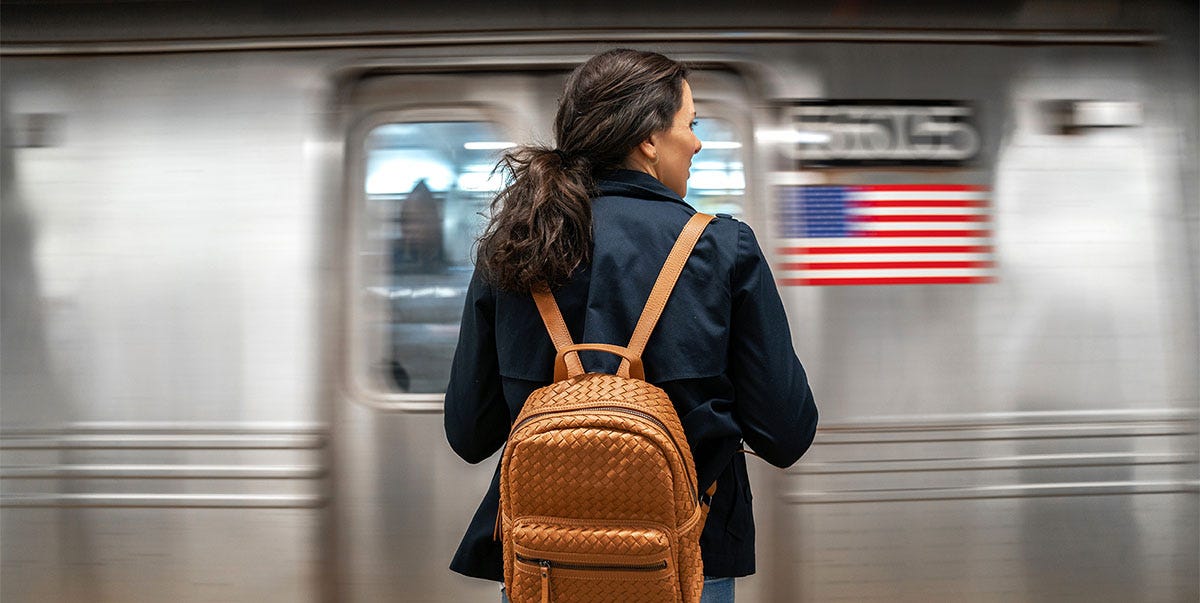 Woman with a backpack waiting for the metro on her way to work