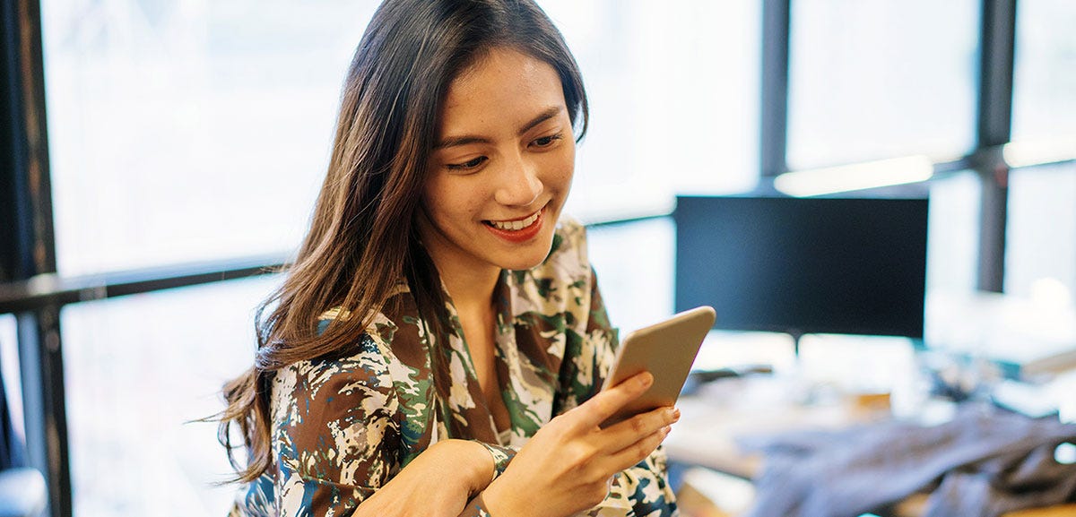 Woman holding a phone and sending messages to her friend
