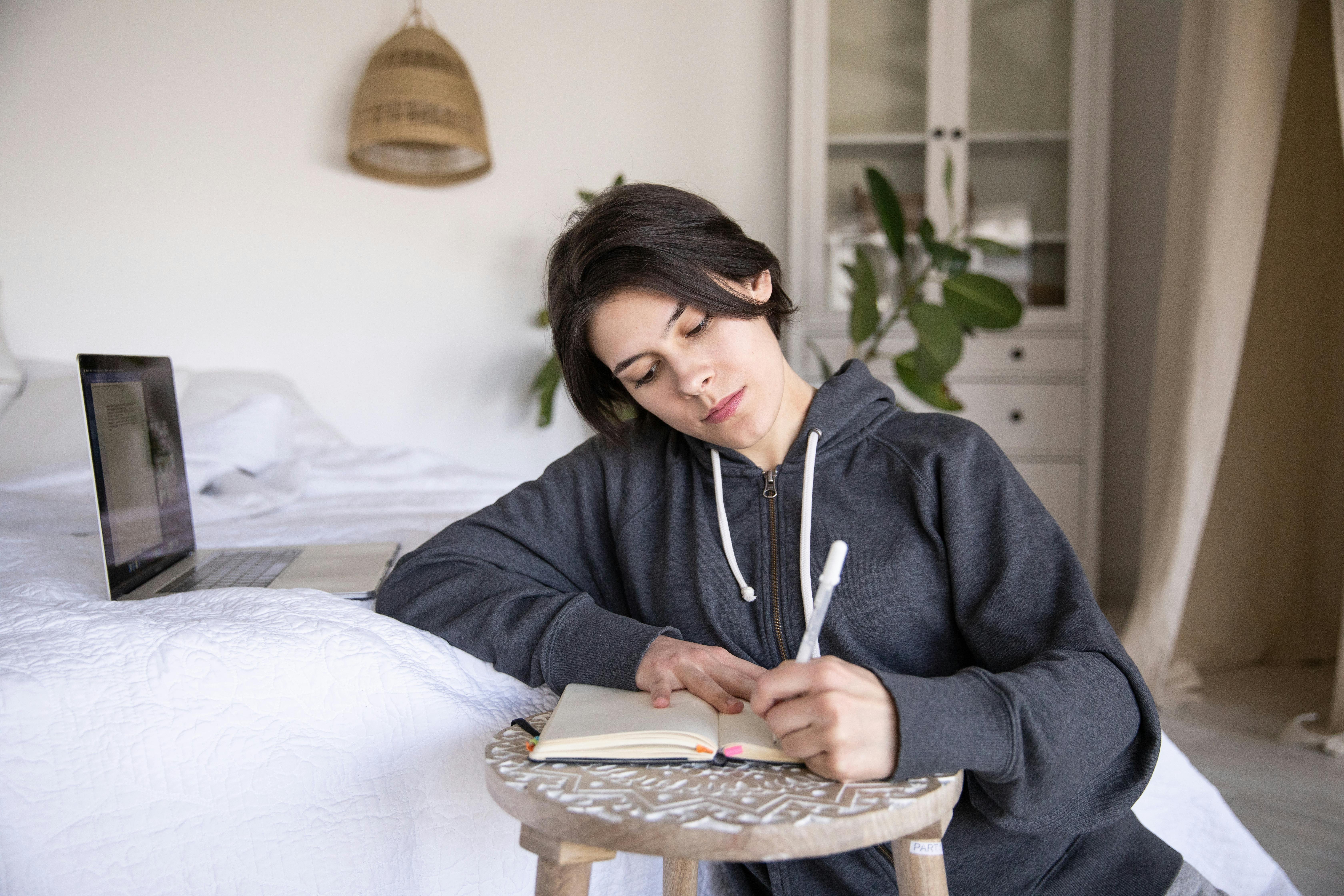Woman writing in her notebook to practice English future simple tense