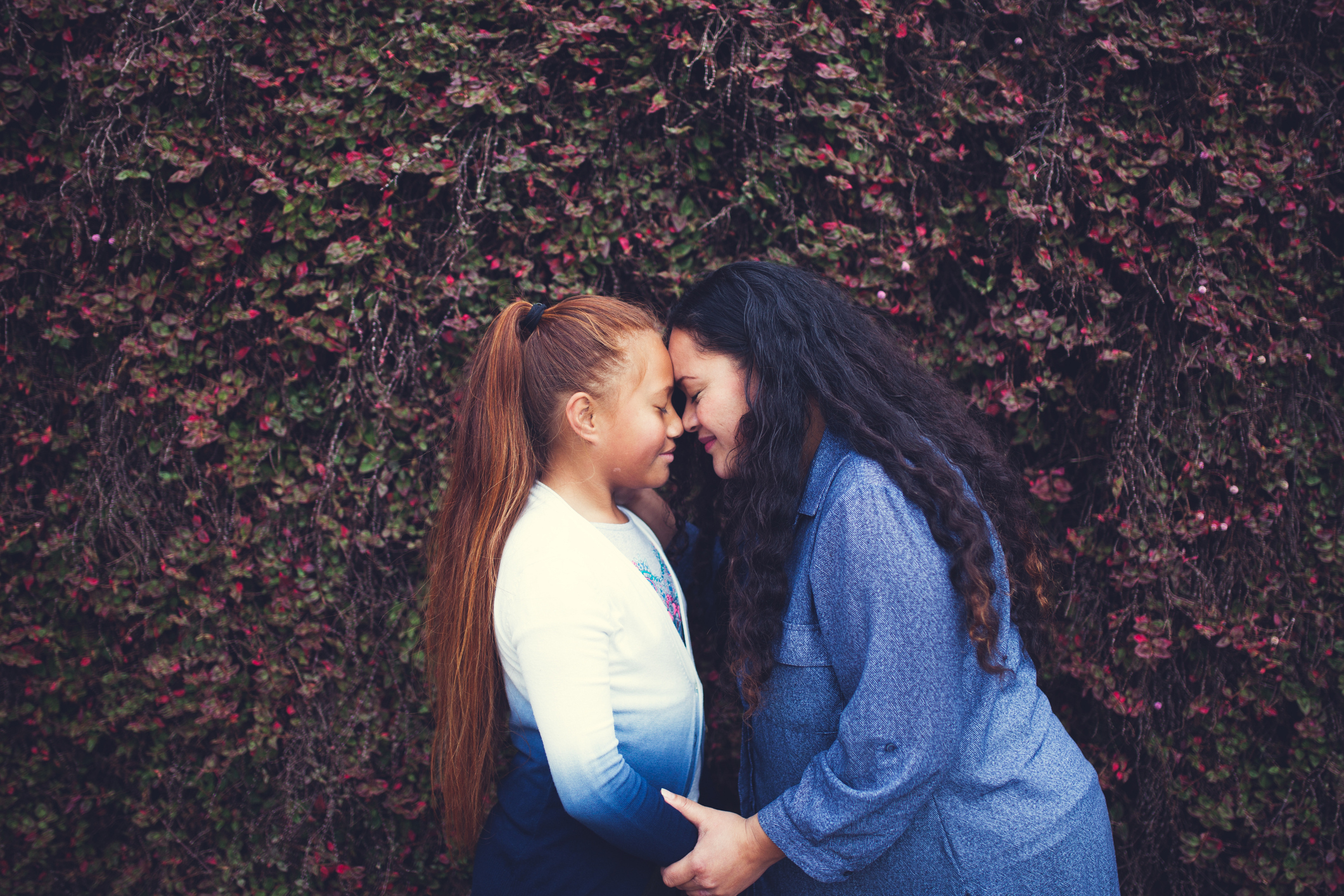 Two women rubbing noses as a Maori greeting in New Zealand