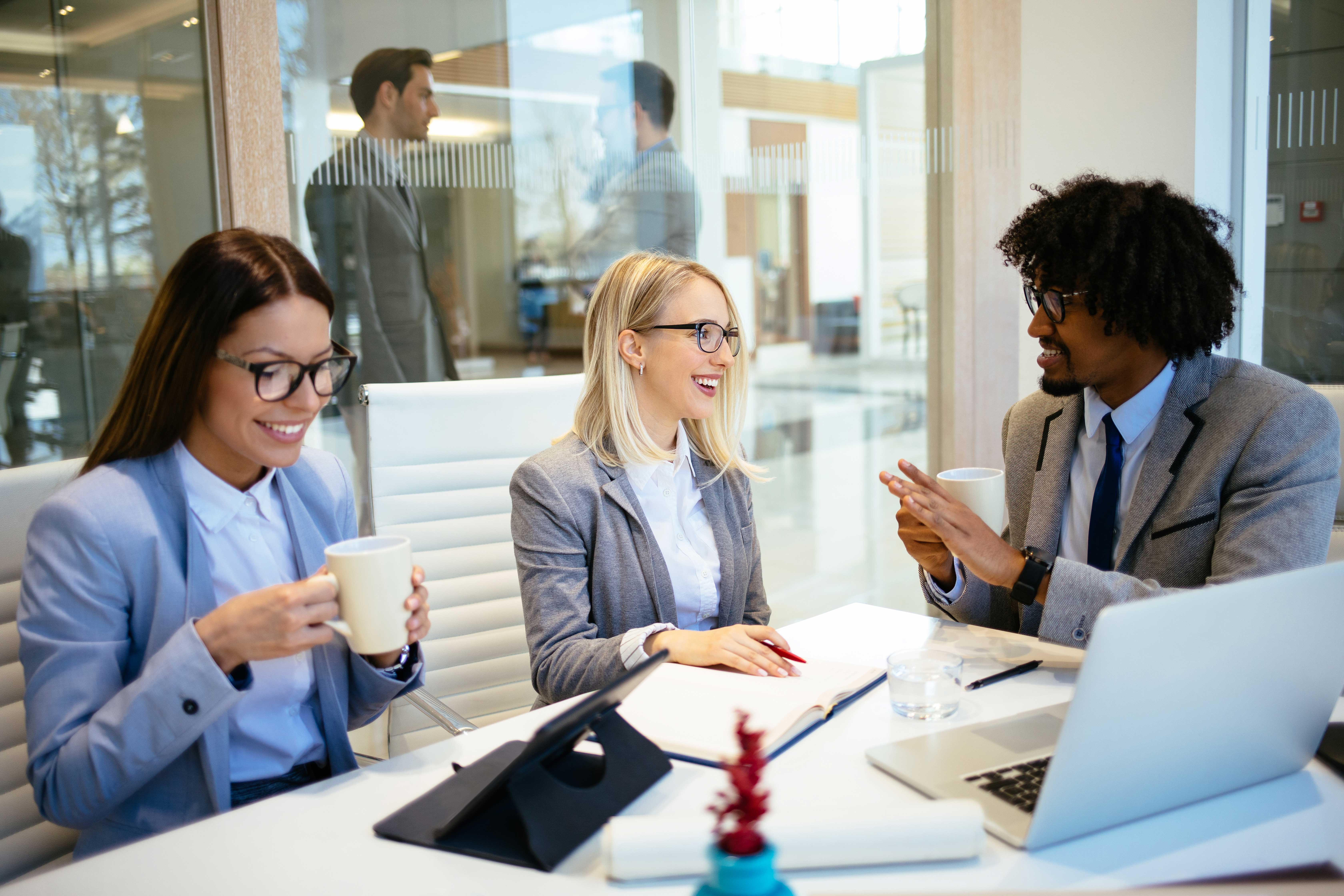 Man and two women talking to each other in a business setting in Italian