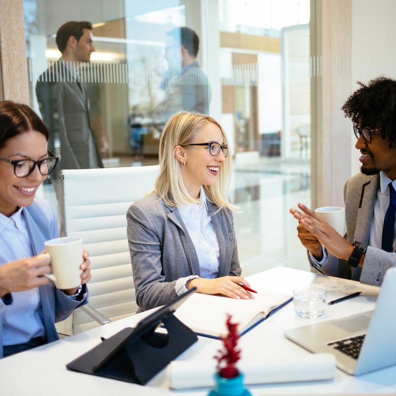 Man and two women talking to each other in a business setting in Italian
