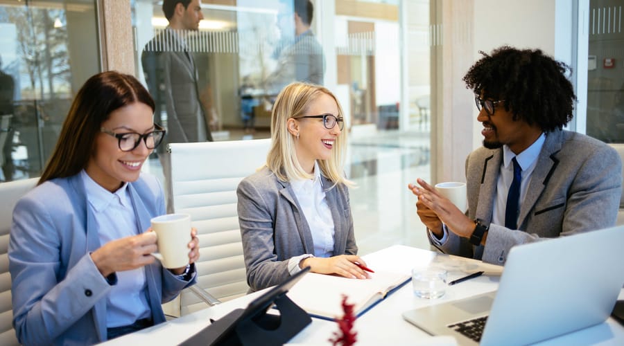 Man and two women talking to each other in a business setting in Italian