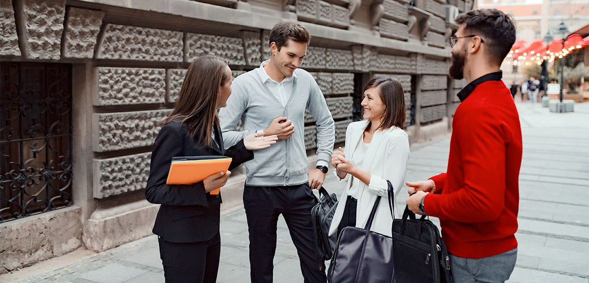 Colleagues on the street chatting with each other about their day