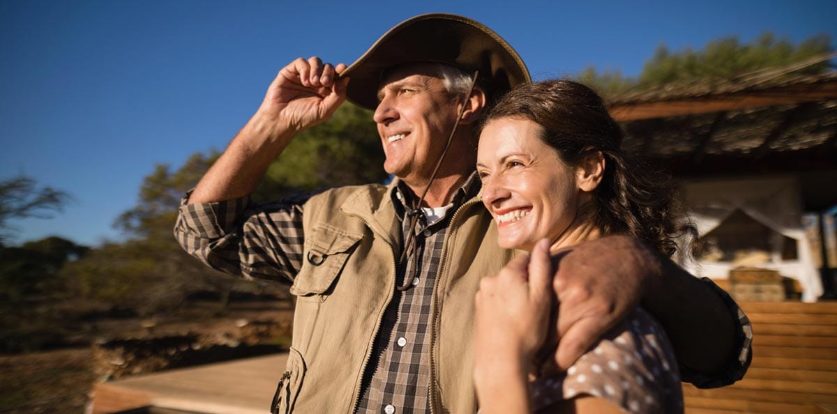 A farmer couple smiling at the setting sun